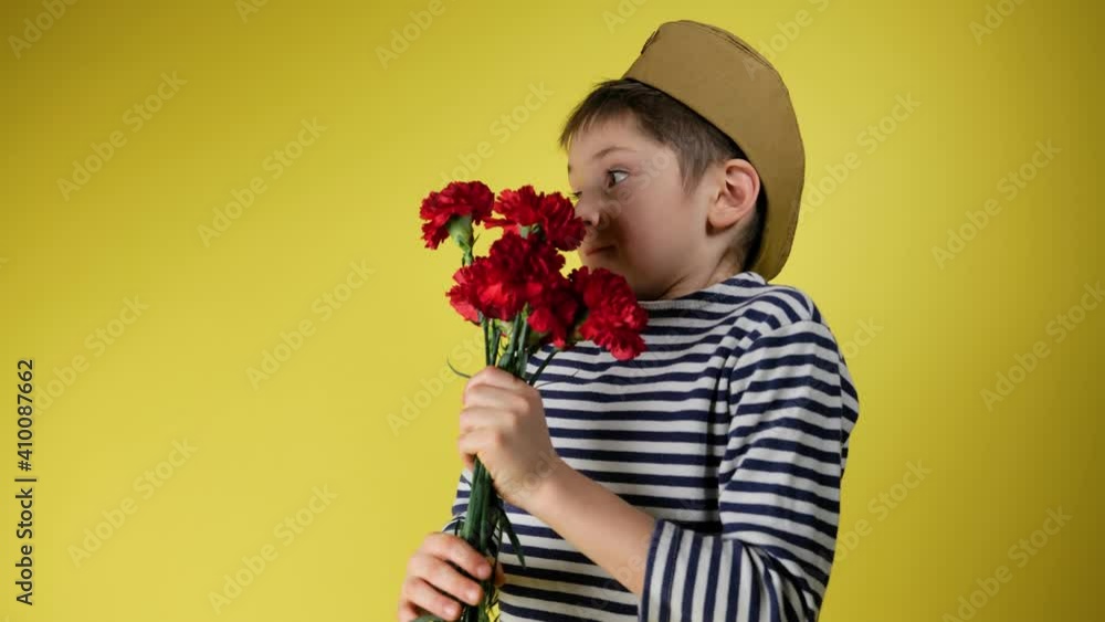 The boy in green military cap with red star throws red flowers carnation May 9 or 23 February, gratitude and remembrance of war and victory day concept, slow motion. Defender of the Fatherland Day The boy in green military cap with red star throws red flowers carnation May 9 or 23 February, gratitude and remembrance of war and victory day concept, slow motion. Defender of the Fatherland Day