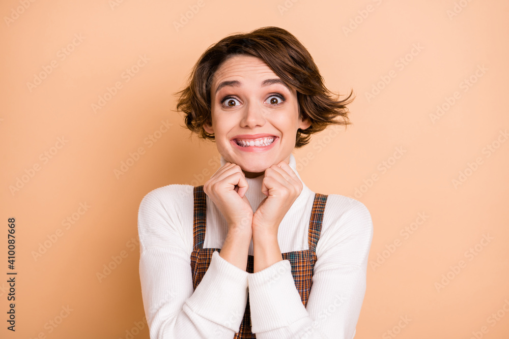Photo portrait of overjoyed happy cheerful girl smiling staring isolated on pastel beige color background Photo portrait of overjoyed happy cheerful girl smiling staring isolated on pastel beige color background