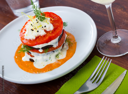 Healthy eating. Stack of fried eggplant with tomatoes, soft cheese and piquant sauce