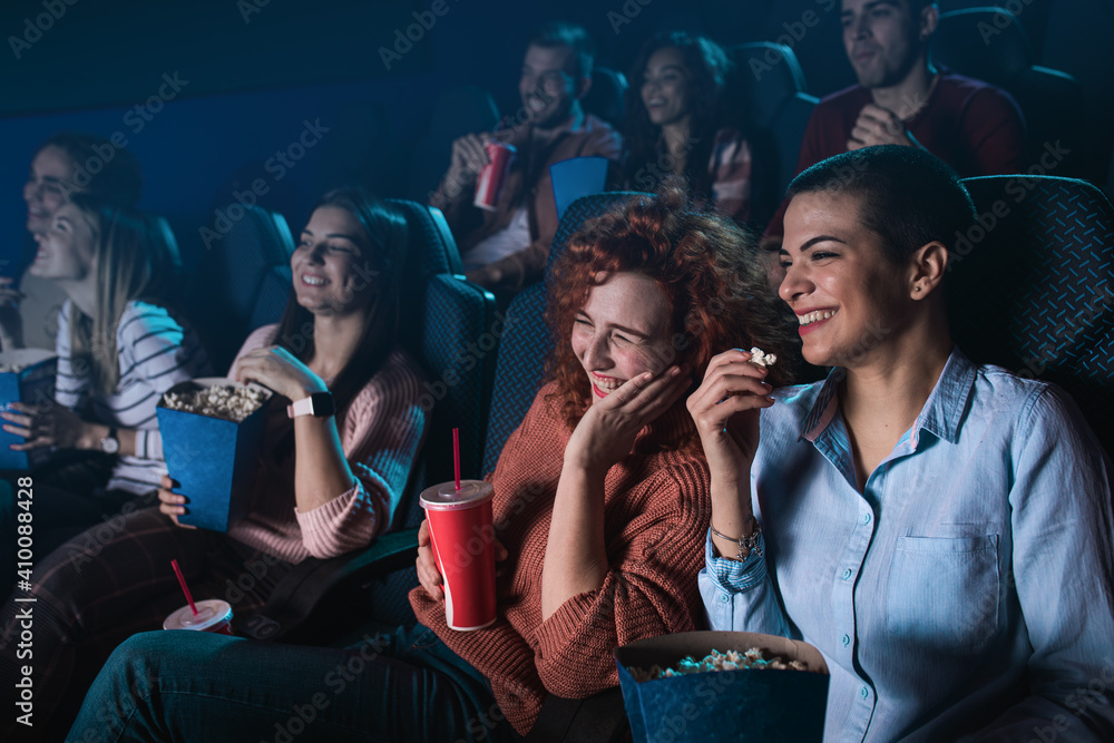 Group of cheerful people laughing while watching movie in cinema. Group of cheerful people laughing while watching movie in cinema.