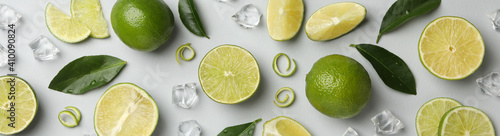 Fresh ripe limes, ice and leaves on whole background © Atlas