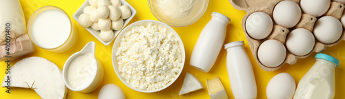 Tableau sur toile Different fresh dairy products on yellow background, top view