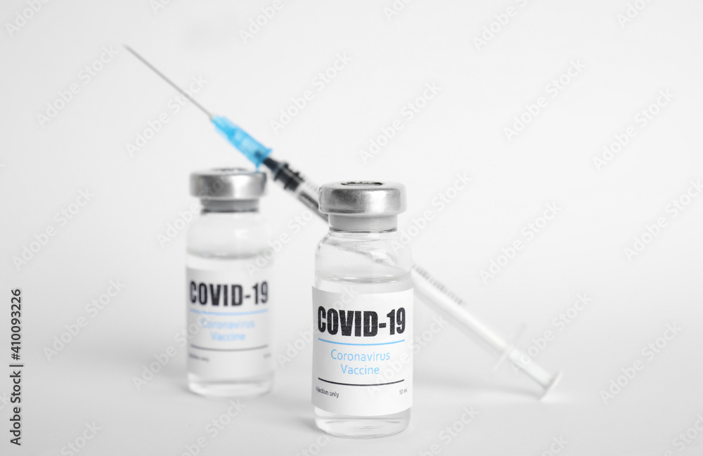 Vials with coronavirus vaccine and syringe on white background Vials with coronavirus vaccine and syringe on white background