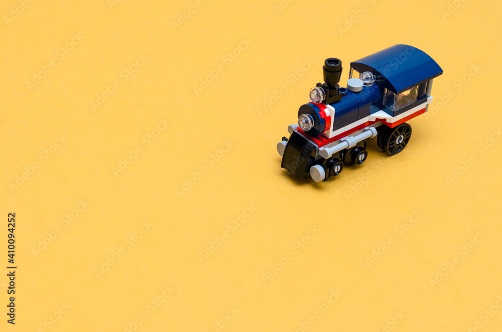 Fototapeta premium Toy steam train on colored paper. Locomotive for the children's railway. Presentation slide for text.