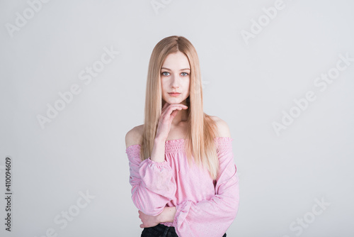 Portrait of a young blonde who poses in the studio on a white background