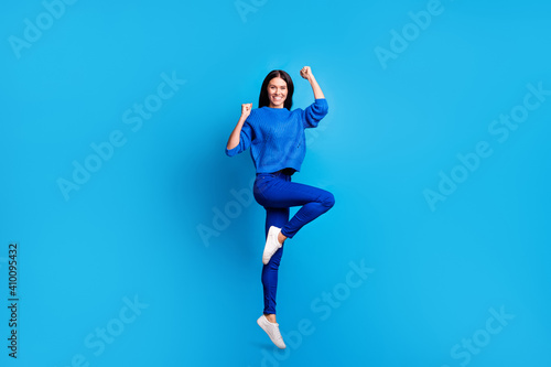 Full size profile photo of brunette optimistic cute lady jump wear blue sweater trousers sneakers isolated on bright background
