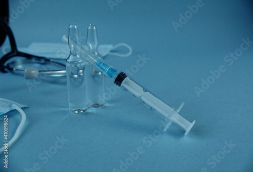 vaccination vaccinated syringe and two vials with lekarts vaccine on a blue blue background with a copyspace