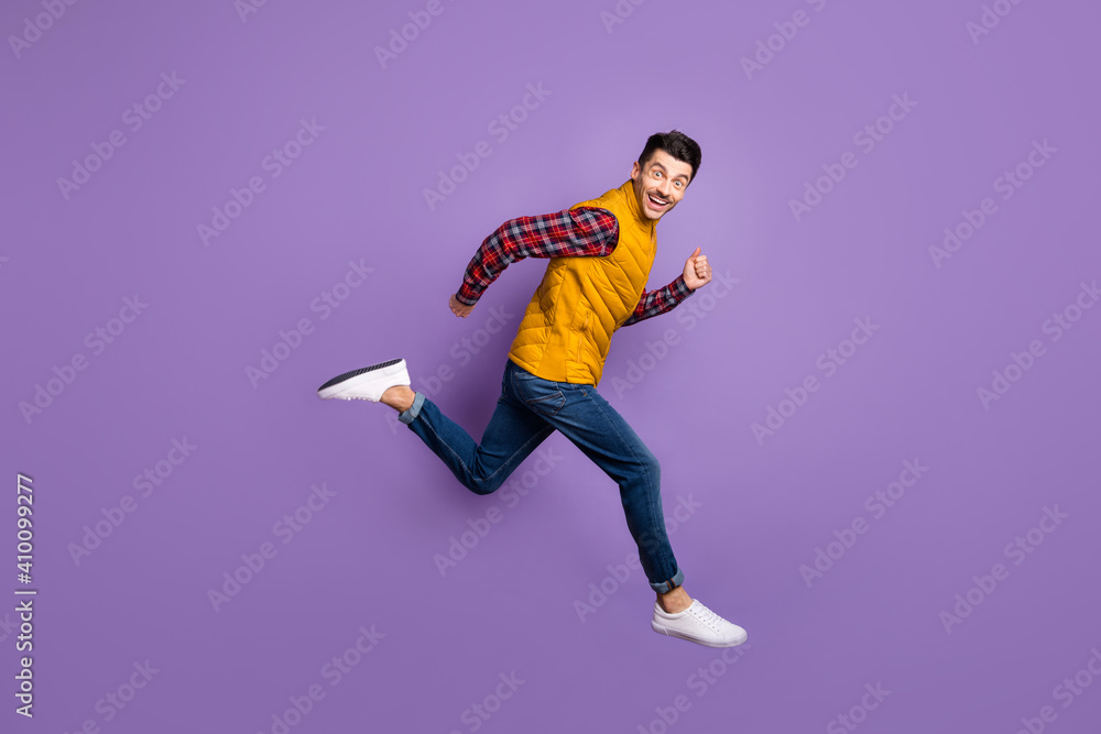 Full length profile side photo of crazy cheerful man jump run empty space sale wear jeans isolated on purple color background