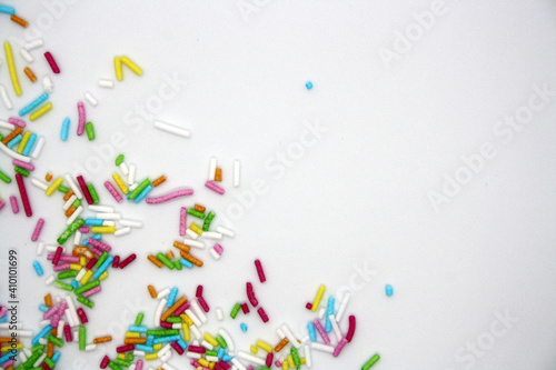 Colorful confectionery sprinkles on a white background.