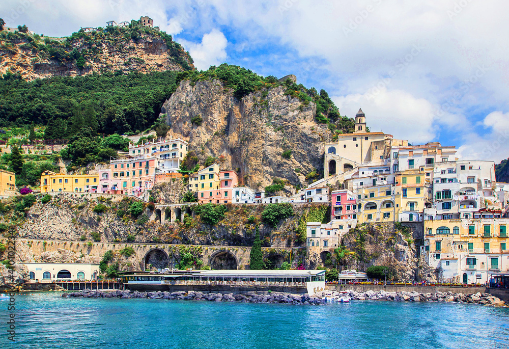 Panoramic view, aerial skyline of small haven of Amalfi village with tiny beach and colorful houses located on rock. Tops of mountains on Amalfi coast, Salerno, Campania, Italy