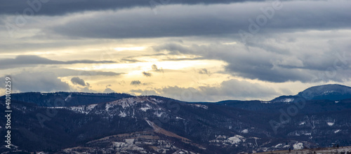 The Sun behind the clouds in winter in the mountains