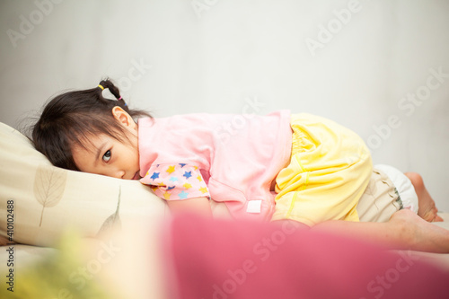 little girl laying on the bed feel angry