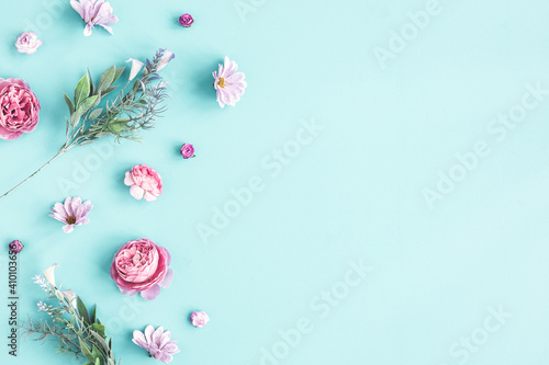 Flowers composition. Pink flowers on pastel blue background. Flat lay, top view