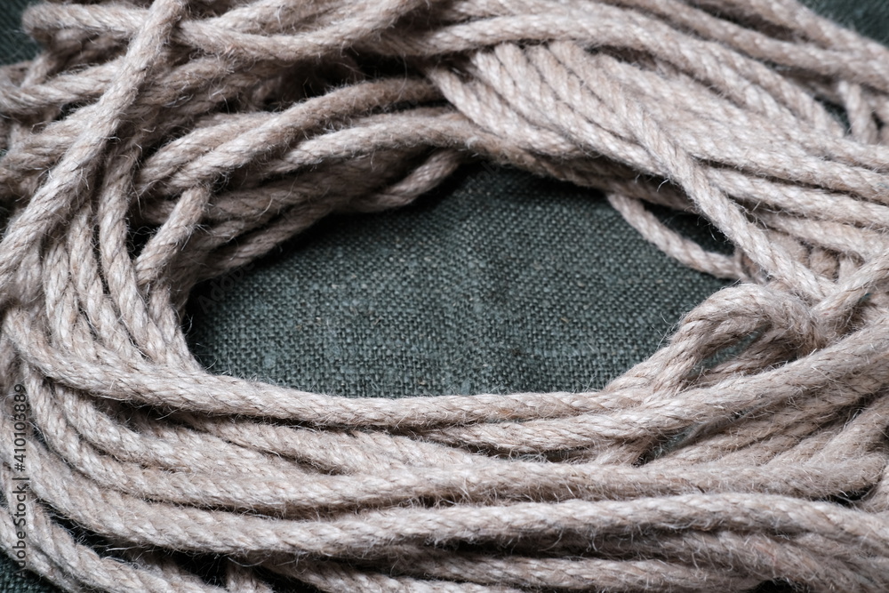 Skein of thick hemp rope on sackcloth. Close-up. Selective focus.