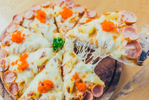 Hawaiian Pizza on wooden plate   photo