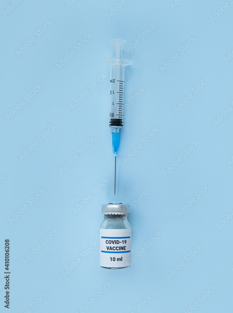 Single use syringe and medical bottle with coronavirus vaccine on blue background. Single use syringe and medical bottle with coronavirus vaccine on blue background.