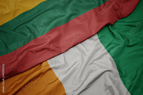 waving colorful flag of cote divoire and national flag of lithuania.