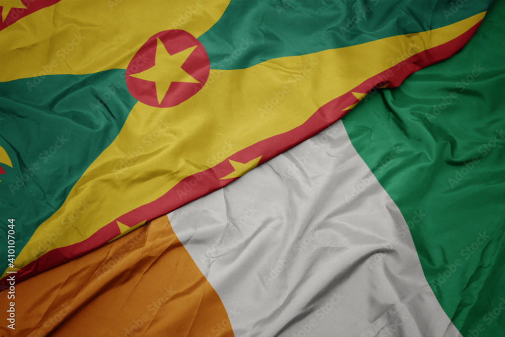 Obraz premium waving colorful flag of cote divoire and national flag of grenada.