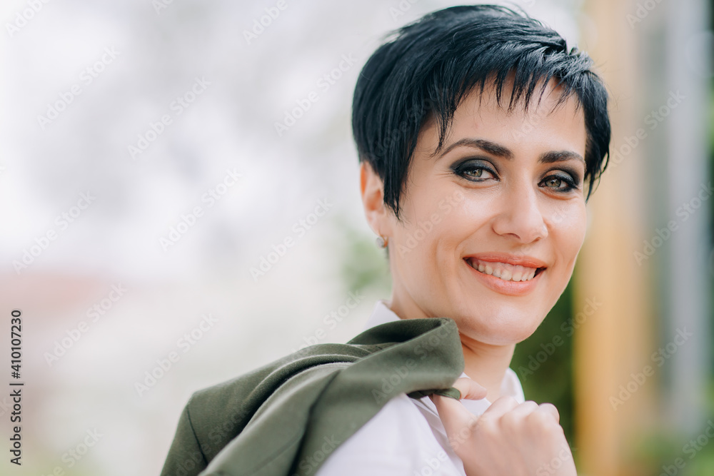 A closeup of cheerful and fashionable woman holding her dress and smiling at camera A closeup of cheerful and fashionable woman holding her dress and smiling at camera