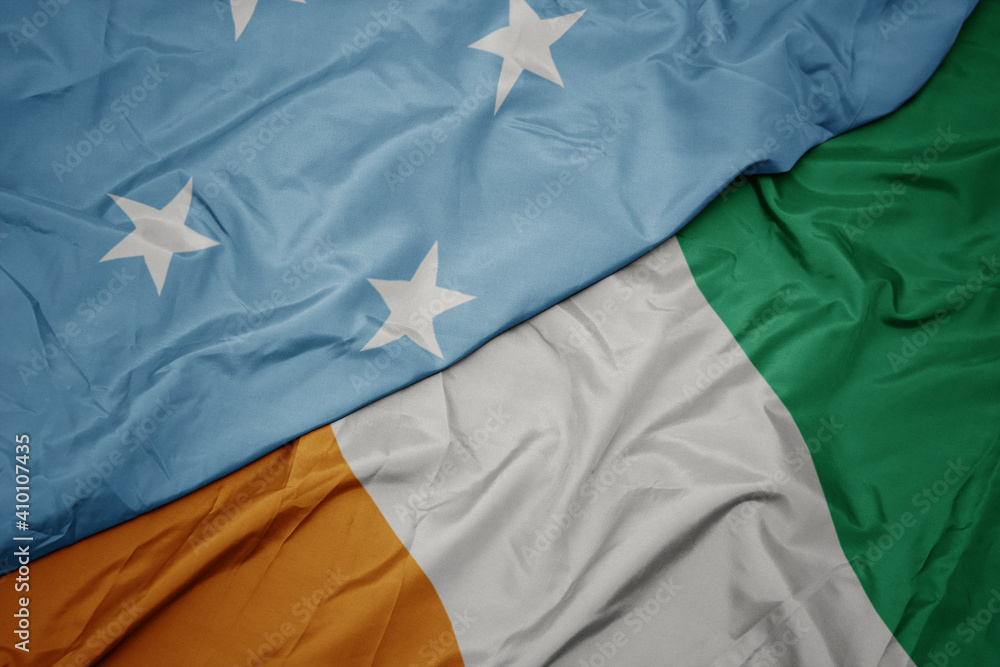 waving colorful flag of cote divoire and national flag of Federated States of Micronesia .