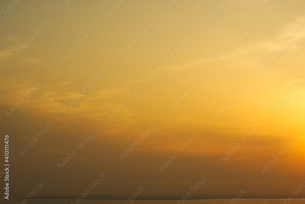 A wonderful nature cover with different shades of yellow-brown sky, some clouds, and a hint of a Sun itself