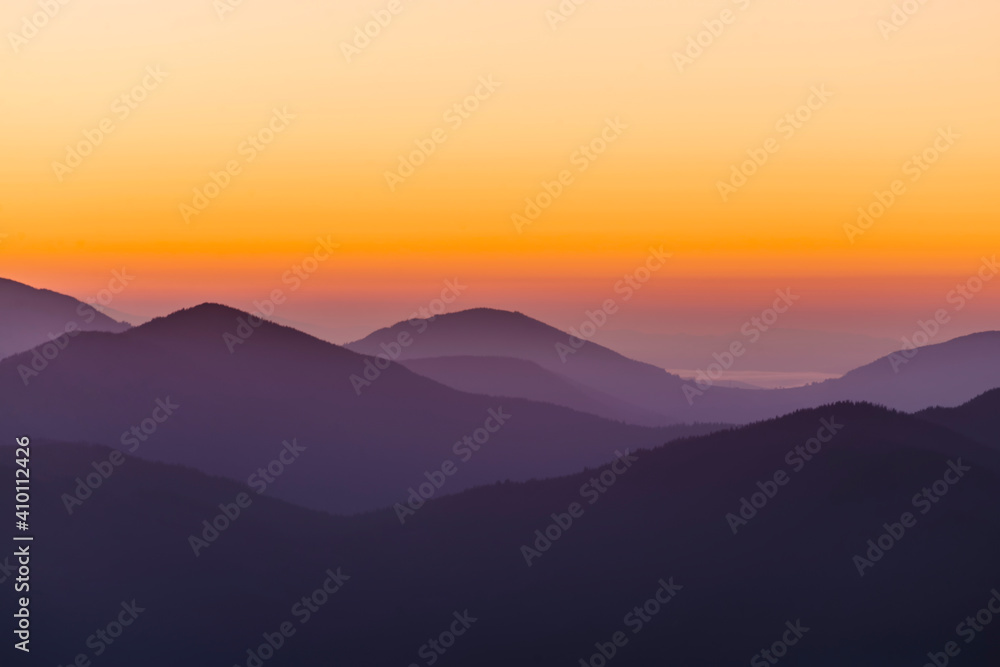 Silhouette of mountain ranges in the haze at dawn.