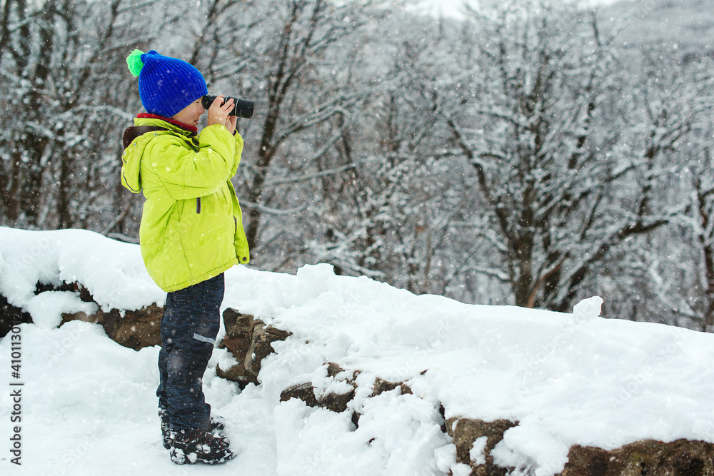 Travel, childhood and lifestyle concept. Winter expedition vacations outdoor. Happy kid at winter nature.