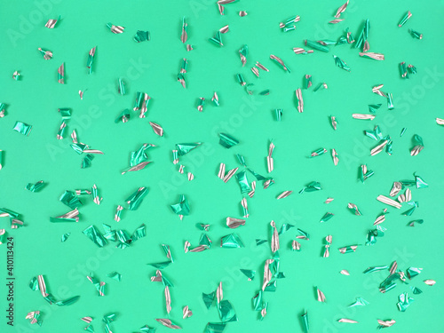 Confetti foil pieces on green background. Abstract festive backdrop. © Анна О