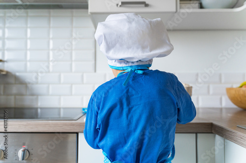 Adorable little boy helping and baking apple pie in home''s kitchen, indoor. photo