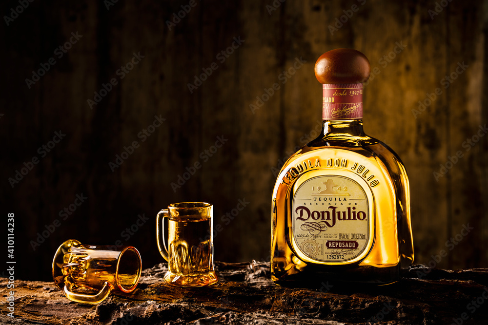 Bottle of Mexican tequila called Don Julio accompanied by two glasses