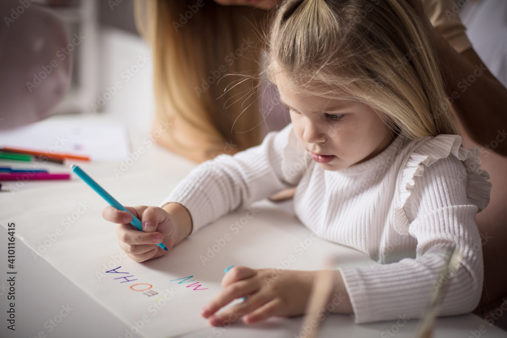 Mother and daughter at home. Little girl drawing. Mother and daughter at home. Little girl drawing.