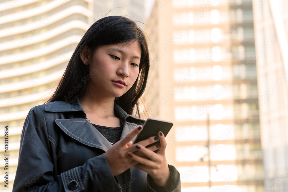 young asian woman consulting her mobile phone