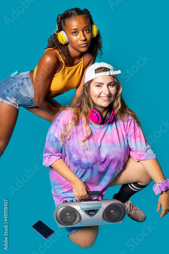 Two young multiethnic friends dancers on blue background