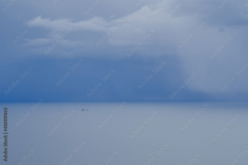 Lonely fishing boat is heading to port near weather front with clouds in sea. Lonely fishing boat is heading to port near weather front with clouds in sea.