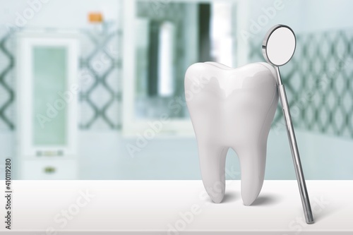 Big tooth and dentist mirror  health concept