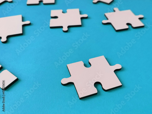 Fototapeta Naklejka Na Ścianę i Meble -  Close-up of white jigsaw puzzle pieces on blue background
