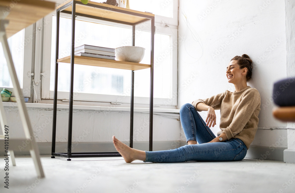 Fototapeta premium Portrait of a smiling creative woman in a modern loft space 