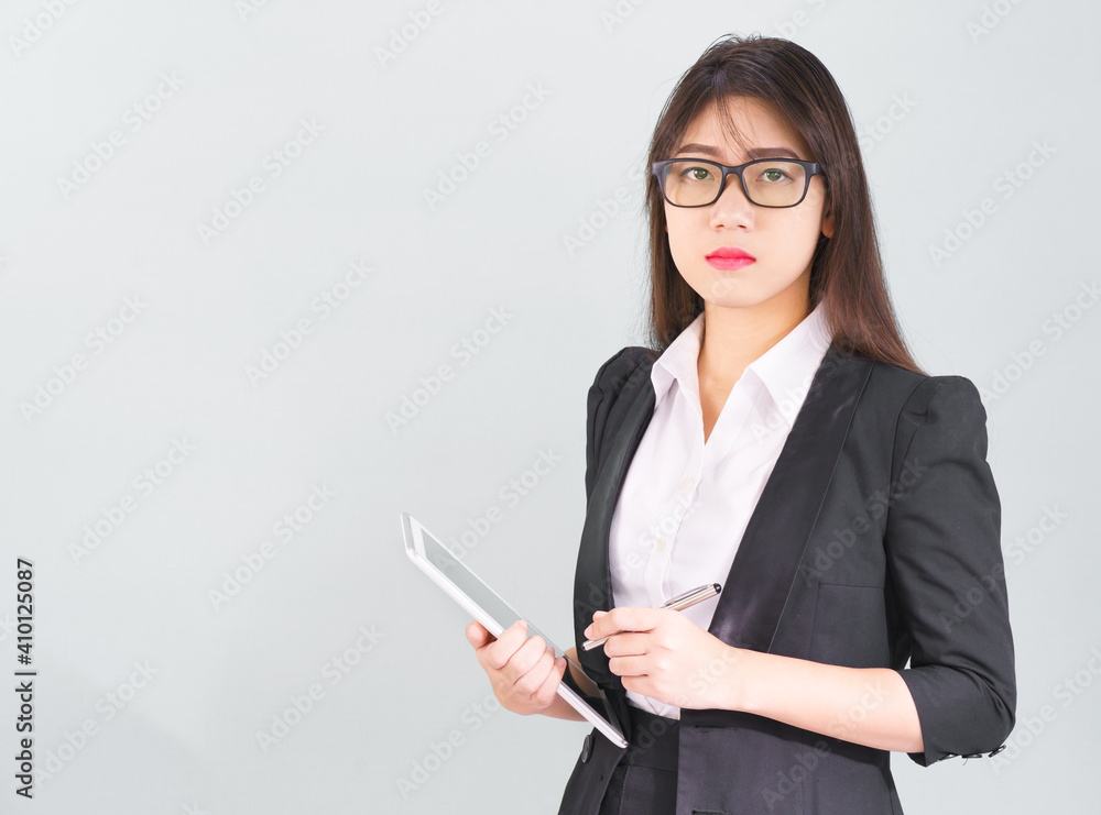Asain women in suit standing using her digital tablet computer Asain women in suit standing using her digital tablet computer