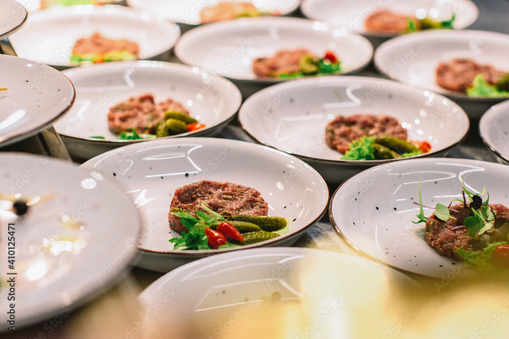 beef tartar with baked toast and egg and cucumbers on a buffet beef tartar with baked toast and egg and cucumbers on a buffet