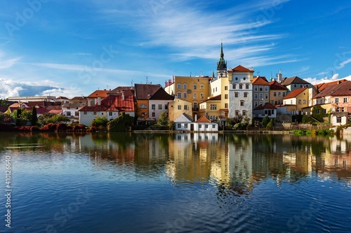 Jindrichuv Hradec, Czech Republic - September 26 2019: View of the cityscape with historical buildings over the small Vajgar lake. Reflection in water. Bright sunny day with blue sky and clouds.