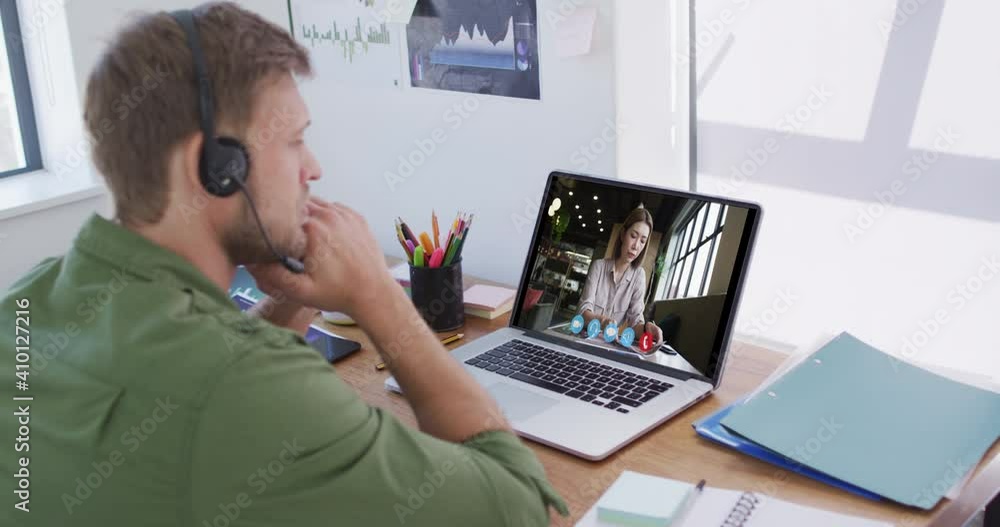 Caucasian man using laptop and phone headset on video call with female colleague Caucasian man using laptop and phone headset on video call with female colleague