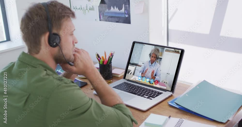 Caucasian man using laptop and phone headset on video call with female colleague Caucasian man using laptop and phone headset on video call with female colleague