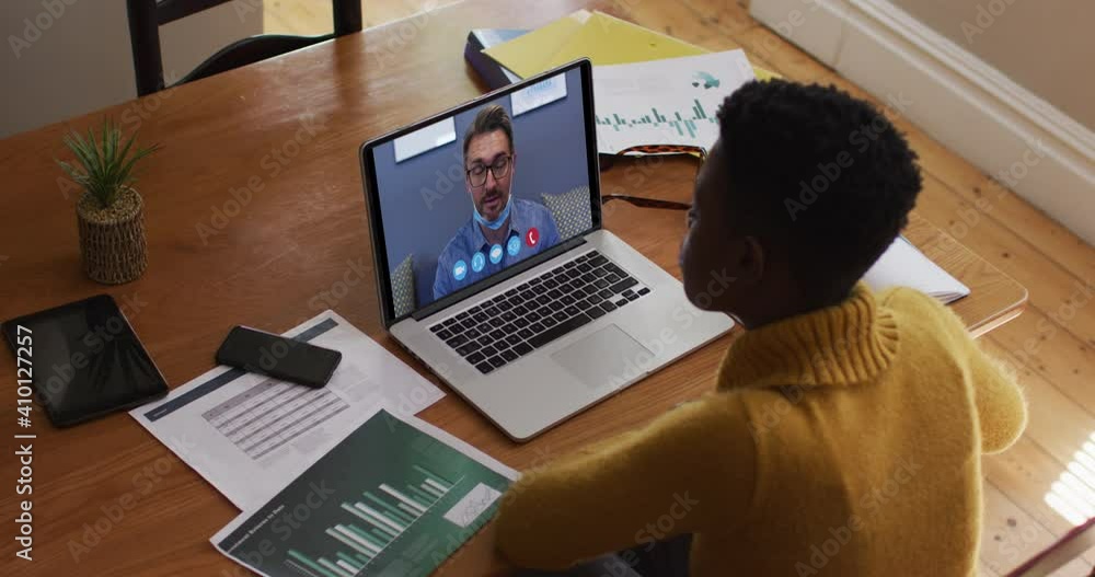 African american woman using laptop on video call with male colleague working from home African american woman using laptop on video call with male colleague working from home