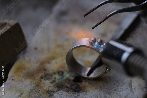 Macro shot. Craft jewelery making with professional tools. A handmade jeweler process, manufacture of jewellery. Melting metal