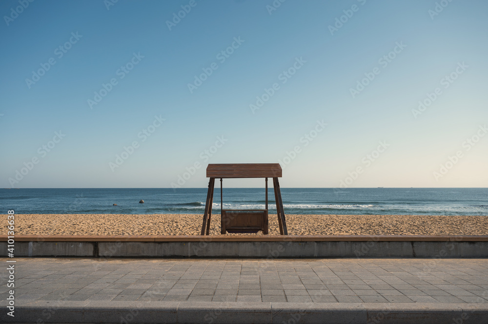 Empty wooden bench on the beach with tropical sea view