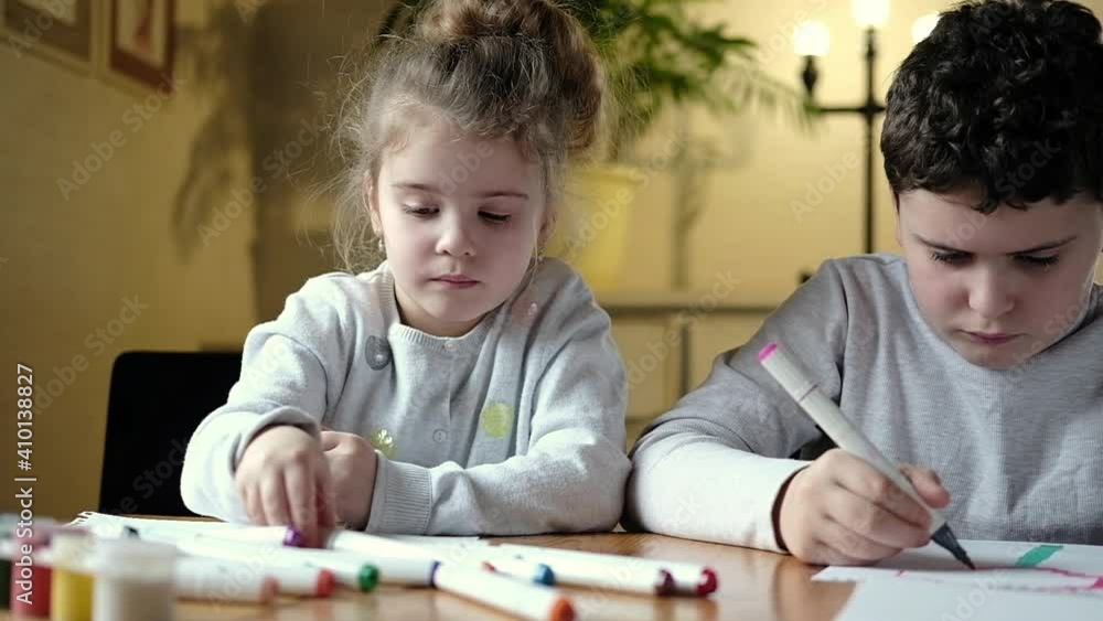 Small preschool cute girl with brother enthusiastically draws with colored pencils. Children's creative family hobby. Teaching children draw school and home. development of imagination and creativity Small preschool cute girl with brother enthusiastically draws with colored pencils. Children's creative family hobby. Teaching children draw school and home. development of imagination and creativity