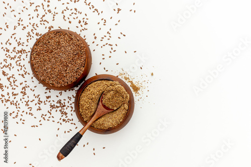 Flaxseeds in a spoon and bowl with a bottle of flaxseed oil and flaxseed flour