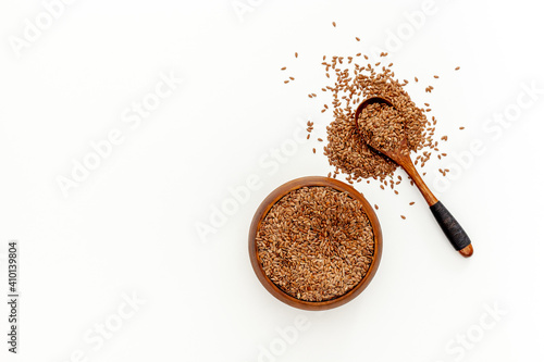 Flax seeds in a spoon and bowl with a bottle of flaxseed oil