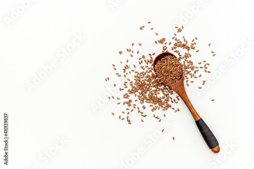 Flax seeds in a spoon and bowl with a bottle of flaxseed oil