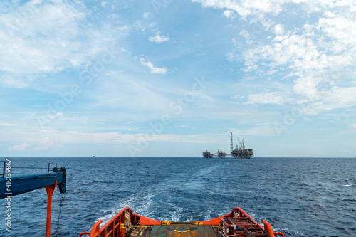 An offshore supply boat leaving oil field after transferring logistic supply to an oil production platform at an oil field